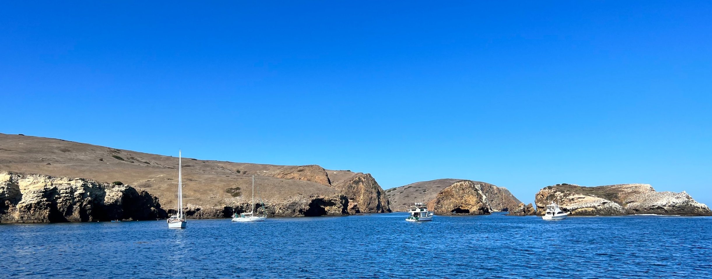 Little Scoprion Anchorage as seen from the boat. We took this picture right after anchoring. By the time we made it to shore and hiked up the hills and took the first picture in this post, most of the boats had left.